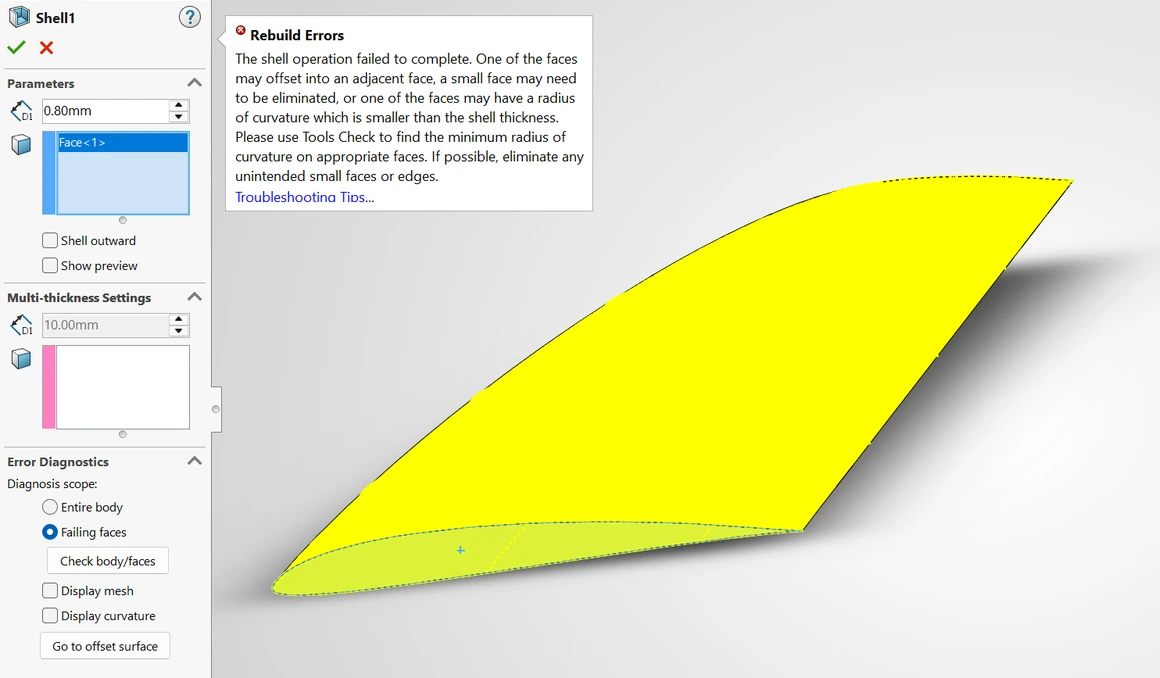 SolidWorks’ Shell panel set to 0.80 mm beside a Rebuild Errors callout saying the shell operation failed to complete, with the wing’s failing faces picked out in yellow.